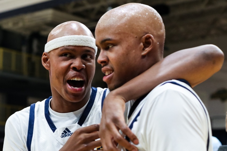 Twin men's basketball players on the court